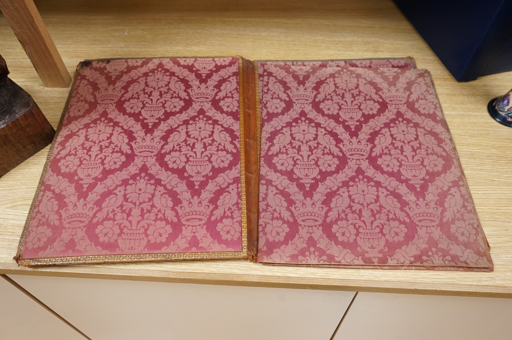 An ornate brass mounted and Morocco leather blotter and a tooled leather blotter of a Persian hunting scene with a red damask lining